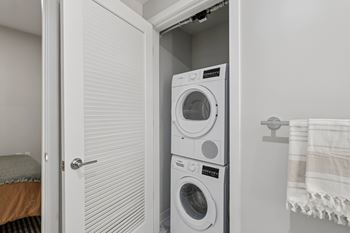 A white washing machine is in a small laundry room.